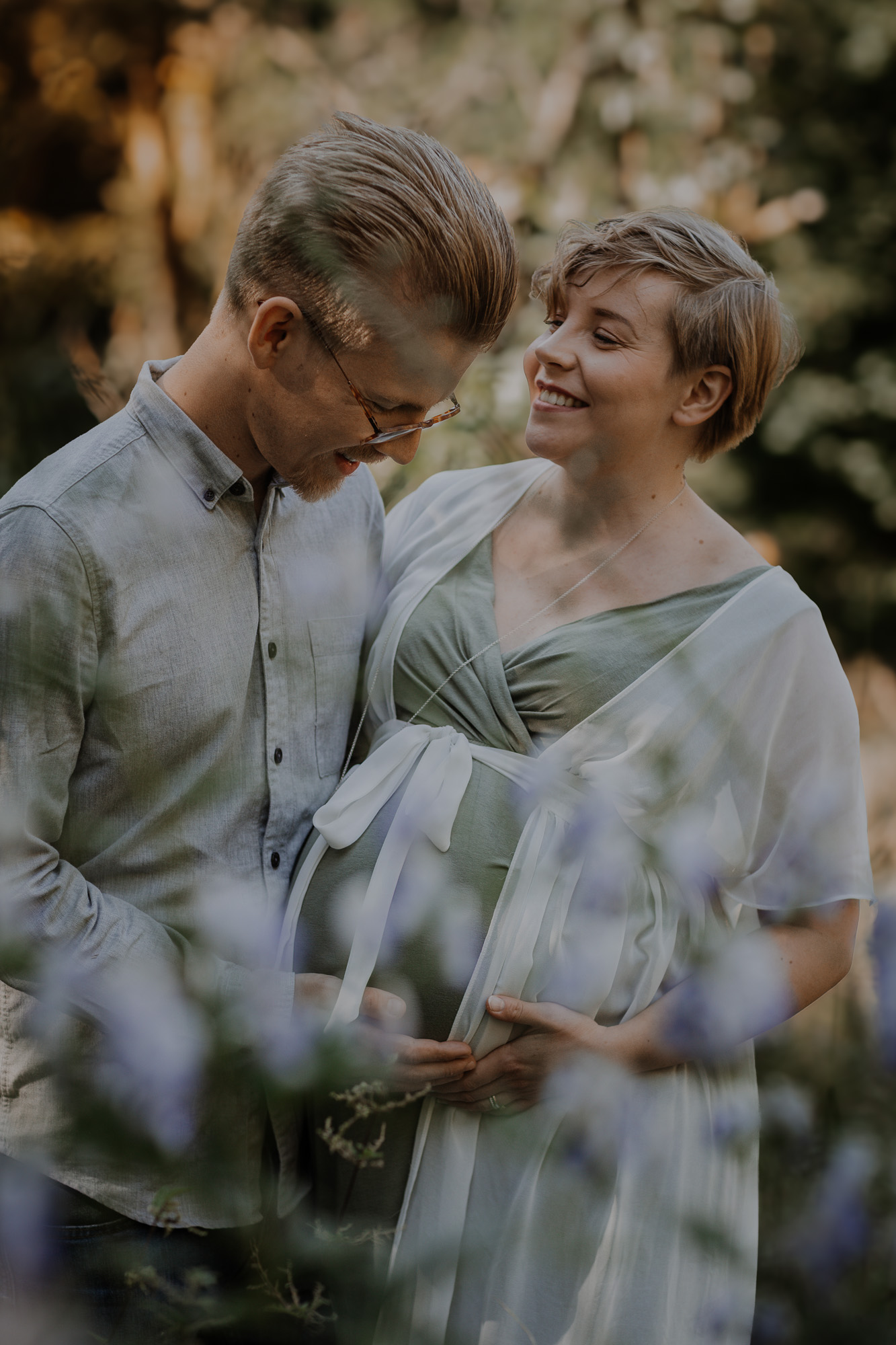 Gravidfoto med blivande föräldrar på äng