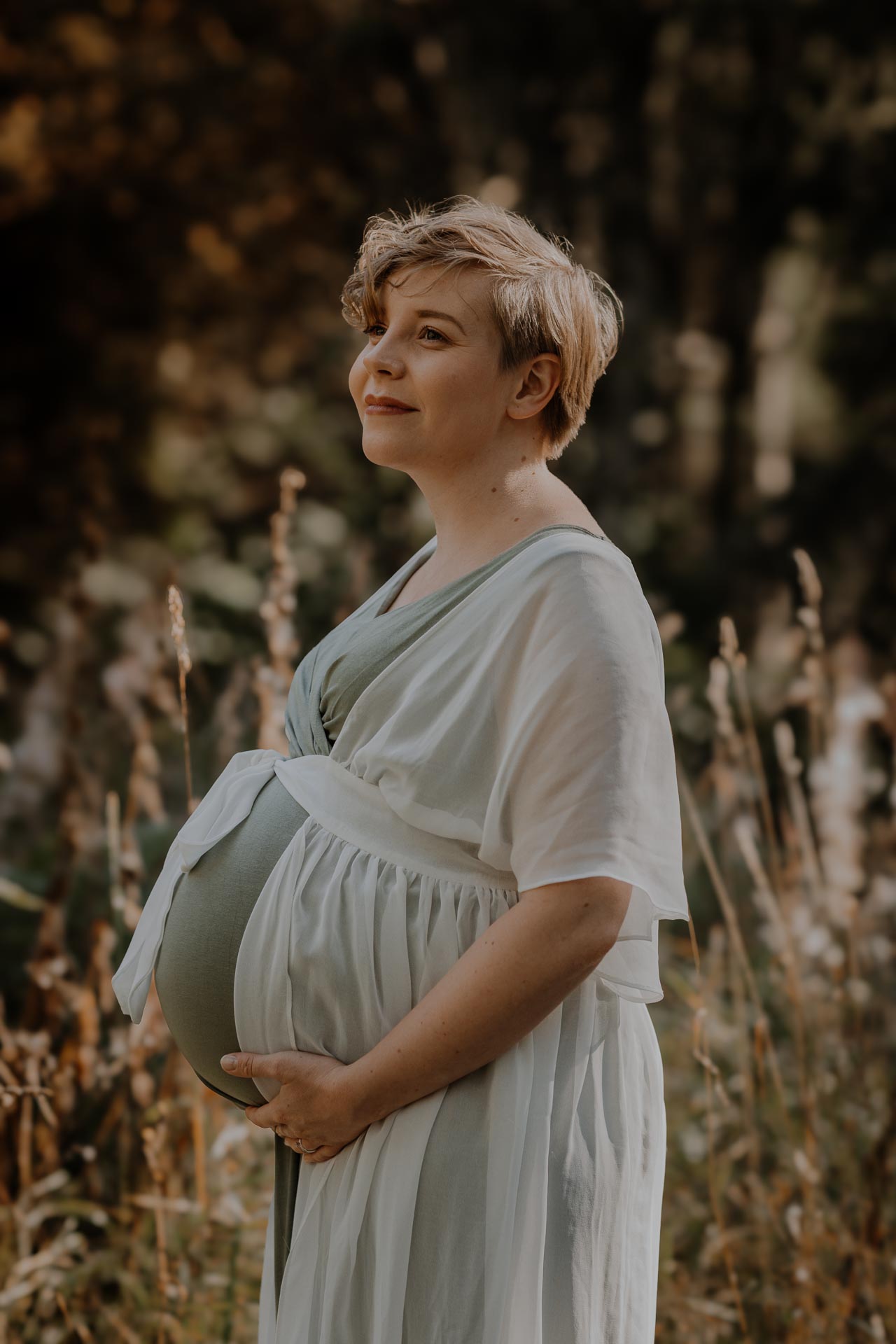 Gravidfoto med blivande mamma på öppet fält